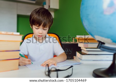 Child doing homework at home. Kids study and learn. Preschooler kid writing and reading. Back to school.