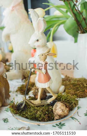 Easter spring decorative composition with easter  eggs and leaf sprigs of flowers and ceramic bunny. on a wooden table