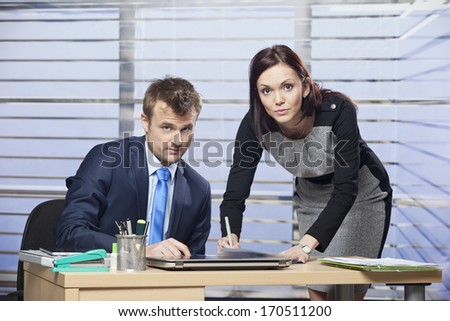 Portrait of a two colleagues signing some documents