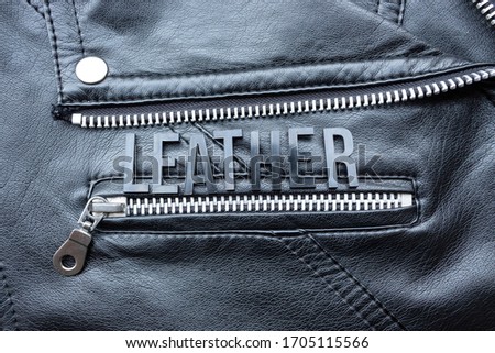 Closeup to a LEATHER lettering word over a black leather biker jacket. Fashion, clothes lifestyle and concept photography