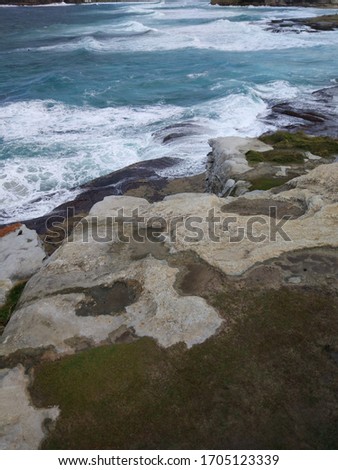 Bondi beach to Cooggee walk on the cloudy day with the rocks and cliffs and pure blue water in Sydney, Australia