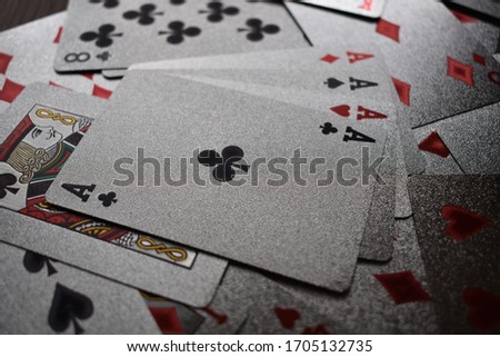 poker cards. texas holdem made with silver, gold and dark materials, on a wooden table, playing poker with a straight face, many numbers aces and kings and queens,plate made of steel