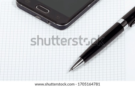 Smartphone, pen and notebook on a white background close-up, business concept
