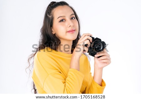 Young beauty Asian woman using camera to take photo and she wearing a yellow sweater shot isolated on white background