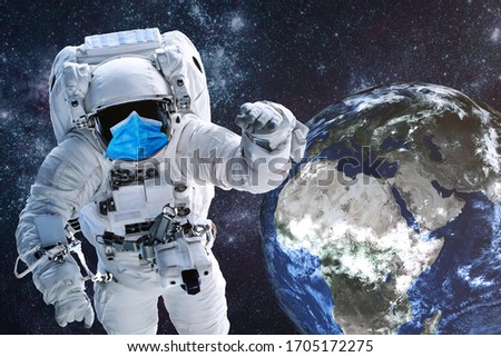 Astronaut in blue medical mask near Earth planet of solar system at night. It is important to wear mask. Science fiction. Elements of the image were furnished by NASA