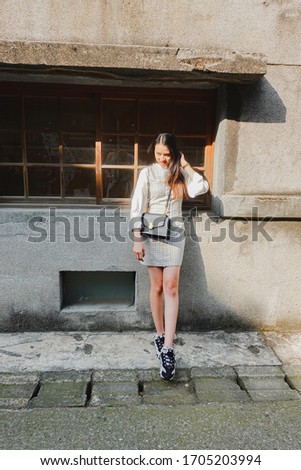 Portrait of beautiful young asian woman posing near building