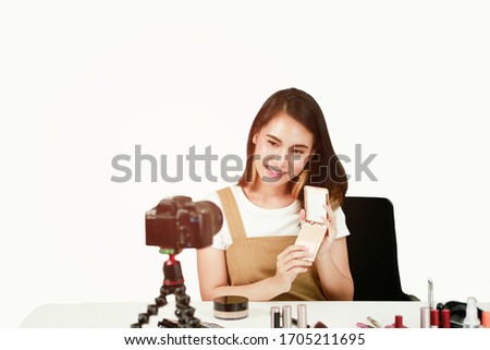 Portrait confident Asian women talking on camera in workplace at home to make video blog for sell colorful cosmetic online. Selling Online Shopping and work from  home influencer youtuber concept