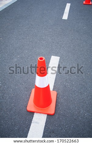 Red cone at roadworks on a tar road