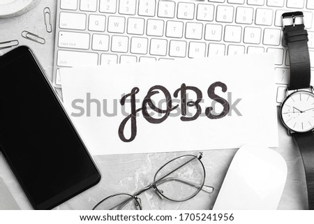 Flat lay composition with word JOBS, computer keyboard and smartphone on light grey marble table. Career concept
