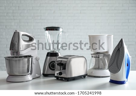 Set of modern home appliances on white table Royalty-Free Stock Photo #1705241998