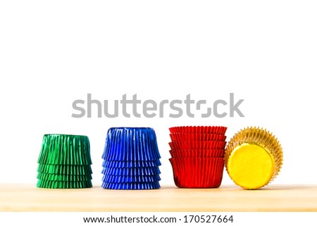Empty colorful foil cup for make bakery on wood table isolated on white background