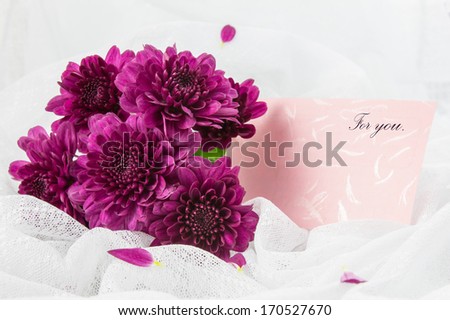 Purple Chrysanthemums with paper card on white fabric