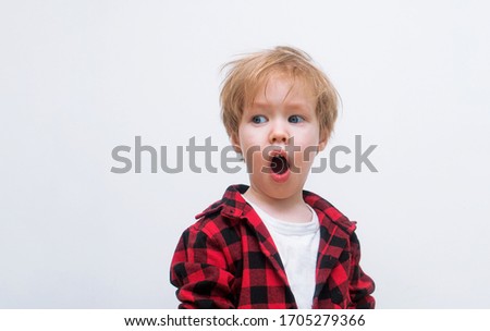 European blond child opened his mouth and is surprised. Kid is looking toward free space. The hipster boy woke up in shock and it was time for him to get a haircut. White background