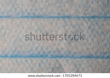 Close up of Surgical Mask showing the blue outer layer of non-woven fibers.