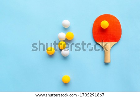 Red racket for table tennis with yellow white balls on blue background. Ping pong sports equipment in minimal style. Flat lay, top view, copy space Royalty-Free Stock Photo #1705291867