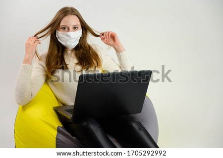 Photo of student girl in mask of freelancer with laptop on a white background