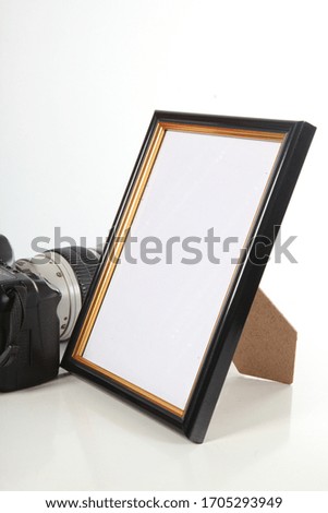 classic black photo frame next to a modern camera