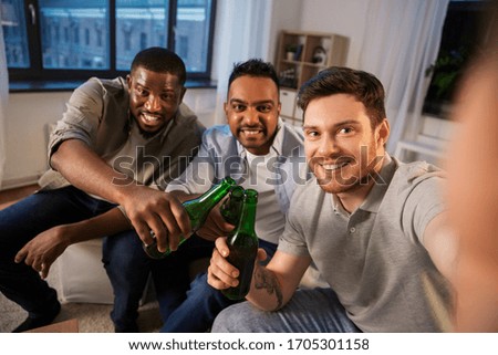 friendship, leisure and people concept - happy smiling male friends taking selfie and drinking beer at home