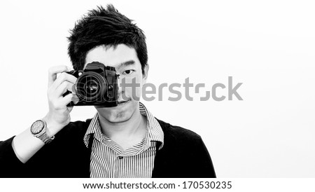 Monotone of asian handsome smart man on casual form shirt in camera taking action. Big professional DSLR camera on his right hand for template of photo shooting advertisement