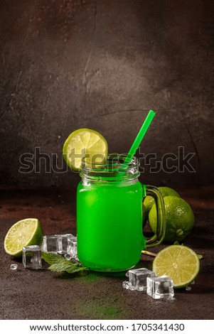 Delicious icy cocktail with fruits on dark grounge background. Healthy colorfull fruit shakes with ice on textured table.
