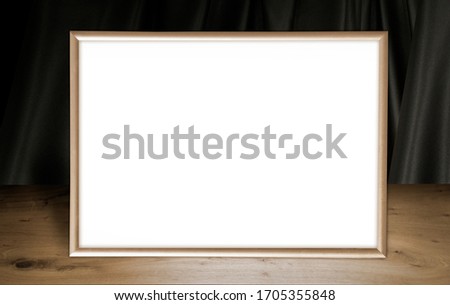 Wooden table, gold frame, dark background with darck drapery. Free space for your design and home interior, mock up