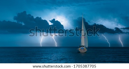 Sailing yacht in a stormy weather with thunder and lightning Royalty-Free Stock Photo #1705387705