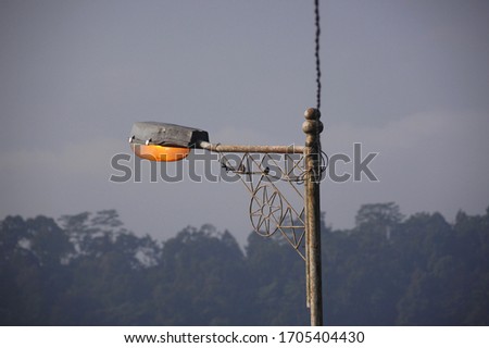 the sparrow perched on a lighted lamppost Royalty-Free Stock Photo #1705404430
