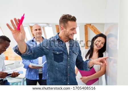 Dynamic Start-Up Business Founder in Seminar Explains Project Idea on Whiteboard Royalty-Free Stock Photo #1705408516
