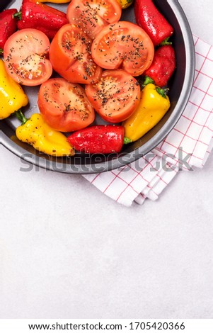 Ripe Tomato and Peppers Ready to Bake Vegetables on Black Plate Vertical Copy Space