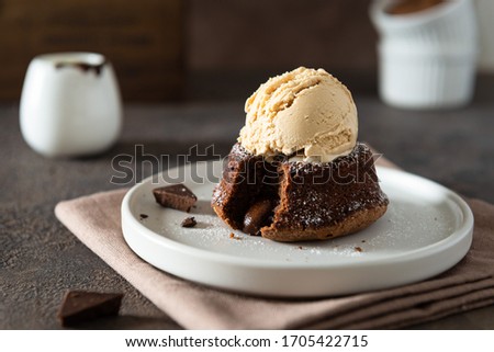 Chocolate lava cake with ice cream served on plate on dark background. Confectionery, cafe, restaurant menu, recipe, cookbook. Side view