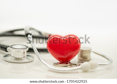 Money, Financial,Saving,Healthcare concept, Closeup of ceramic red heart,stack of coins and stethoscope on white background and copy space for text.