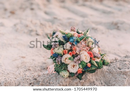 On the sandy beach are the bride's wedding bouquet. Floral bouquet of different flowers, copy text