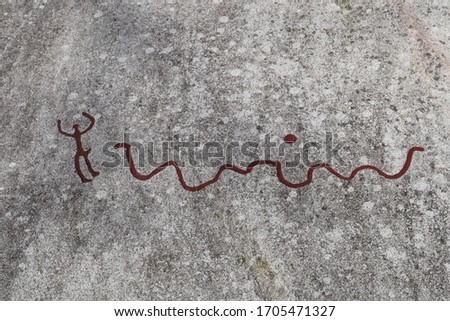 3000 year old rock carvings from the bronze age, showing a man running away from a snake, Tanum, Sweden