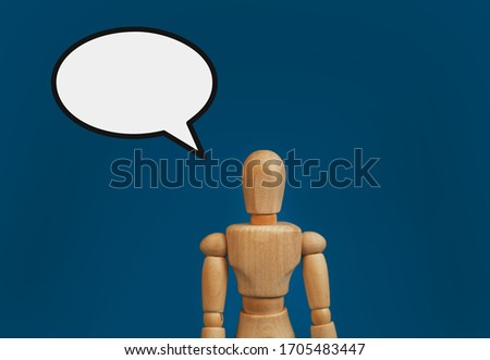 wooden figure on a blue background with a cloud template for text