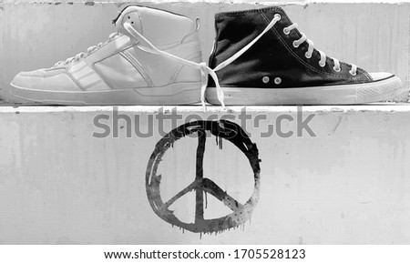 White and black shoes holding laces and giving message of peace.
