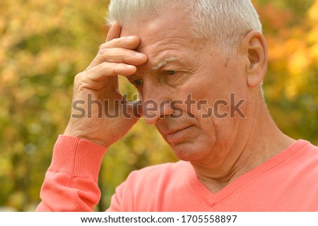 Close up portrait of senior man thinking in park