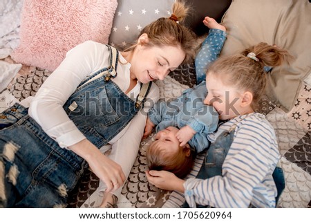 Mom and daughters in jeans clothes at home