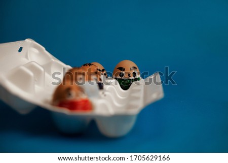 a bunch of masked eggs during Quarantine. on a blue background.