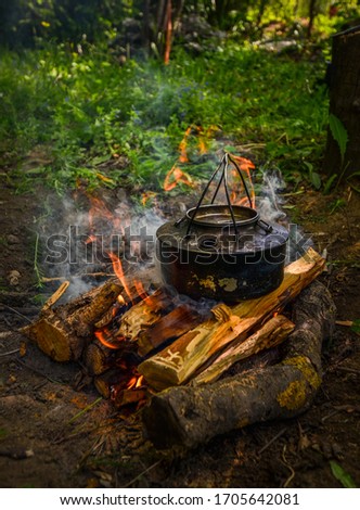 Picture of a coffee-kettle heating up over a wood fire