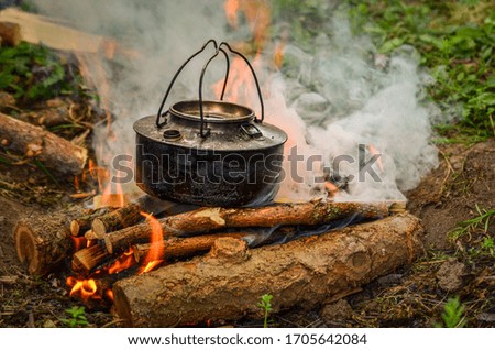 Picture of a coffee-kettle heating up over a wood fire