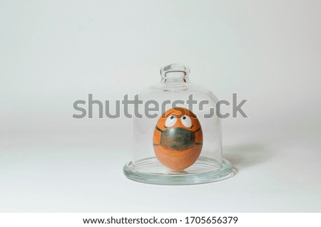 Egg in a medical mask in a glass flask.
