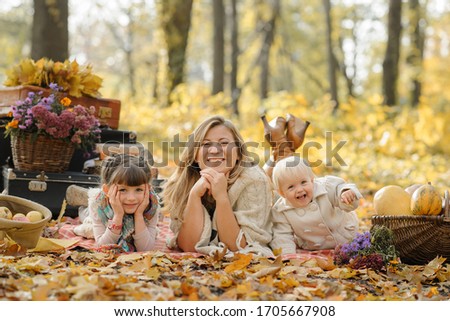 Autumn portrait of mom with daughters in the autumn park.