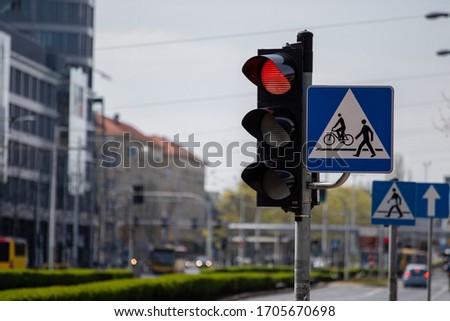 Traffic light signaling red light. Pedestrian crossing road sign on the road. City traffic