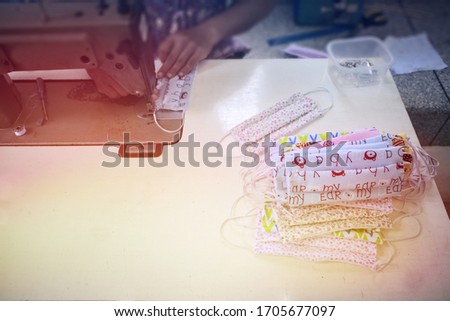 White table Sewing machine table Cartoon pattern sewing Cloth mask pile Colorful fabric fresh sunlight Old sewing machine Making a cloth mask Plant protection contact Cloth mask factory copy space