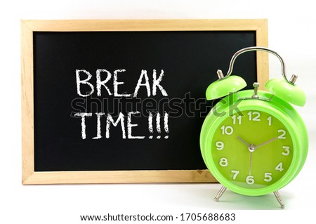 Mini blackboard written break time with alarm clock over white background.Noise and grain effect applied and selective focus. Royalty-Free Stock Photo #1705688683