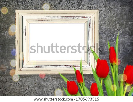 Dark retro background with old frame, red tulips, bokeh on black grange wall