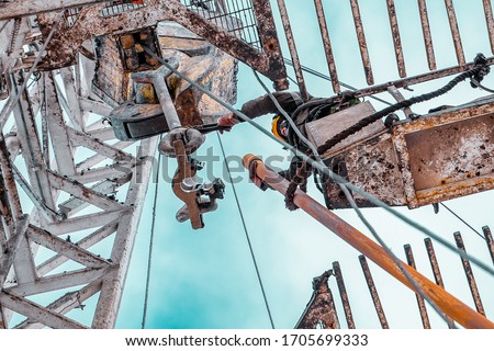 Offshore oil rig worker prepare tool and equipment for perforation oil and gas well at wellhead platform. Making up a drill pipe connection. A view for drill pipe connection from between the stands Royalty-Free Stock Photo #1705699333