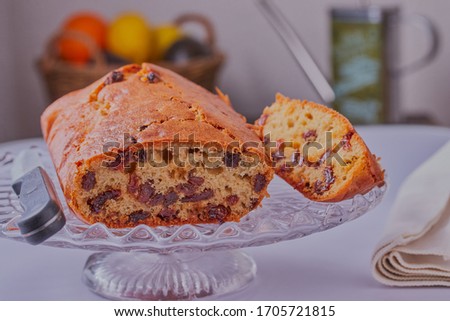 Sultana cake that has been sliced, on a cake stand,shot close up on a white table.
