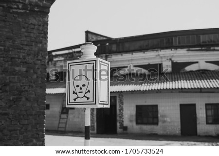 Black and white photography of abandoned empty building and death street sign.