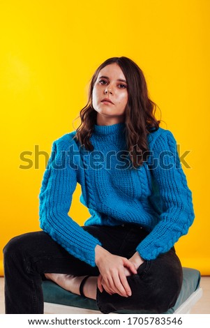 Beautiful fashionable brunette woman in blue sweater